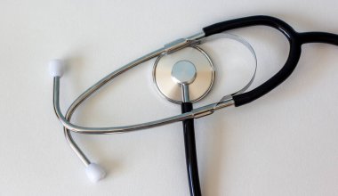 Stetoskop mavi bir arkaplanda izole halde yatıyor.