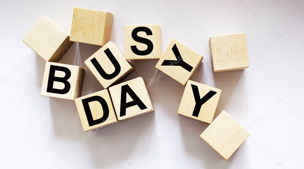 Busy day written on wooden cubes and white background