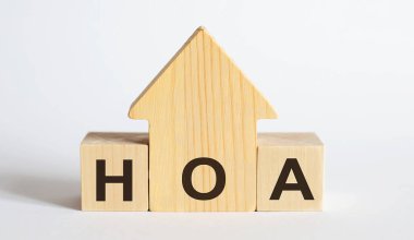 Wooden blocks with the word HOA , house. The concept of the high cost of rent for apartment. Real estate market. clipart