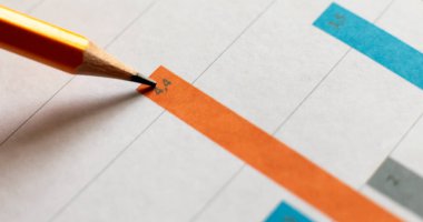 Beyaz masada kalemle birlikte iş grafiğinin en üst görüntüsü.