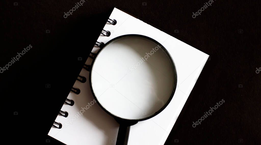 Opened old blank book with magnifying glass. . Empty place for text.