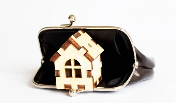 Buy house concept. Miniature house in the black wallet