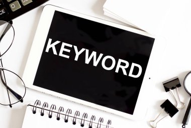 KEYWORD metni. Ofis araçlarıyla beyaz arkaplan üzerine iş kavramı