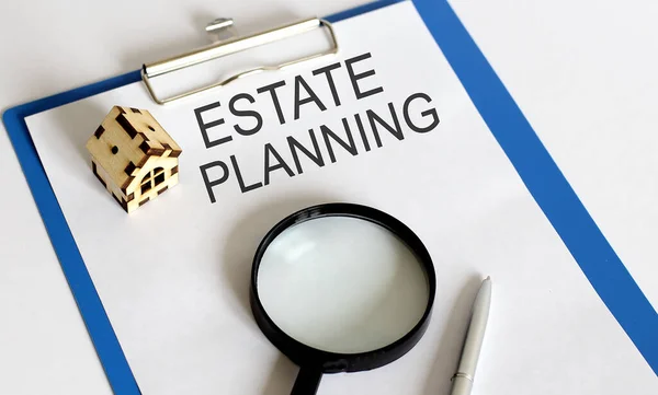 Estate planning text .Home planning concept whith magnifier, pen and wooden house