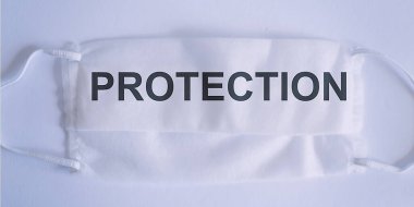 Beyaz arkaplan üzerinde metin ifadesi PROTECTION. Kirliliğe, virüse, gribe ve koronavirüse karşı maske koruması.