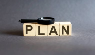 Plan Kelime Engelleme iyi ve gri arka planda büyüteç. Gelir, giderler, vergi, mali veriler.