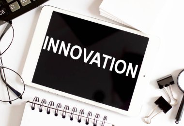 Ofis araçları ile beyaz arkaplan üzerine INNOVATION İş Kavramı
