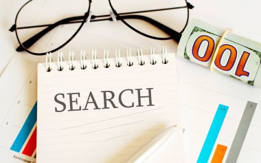 İş raporları, boş kağıt kağıtlar, gözlükler, tablolar - SEARCH metin ile ofis masa çalışma alanının doğrudan üst görünümü.