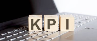 Dizüstü bilgisayarında KPI konsept metni olan tahta bloklar