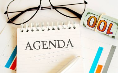 İş içi boş kağıt tabaka, gözlük ve çizelgeler - AGENDA metin ile ofis masa çalışma alanı doğrudan üst görünüm.