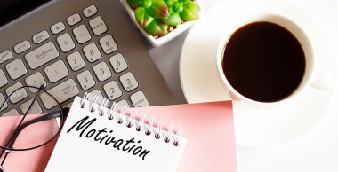 Ofis malzemeleri, cihazlar, kahve fincanı ve bardaklar yazı motifli beyaz masada.