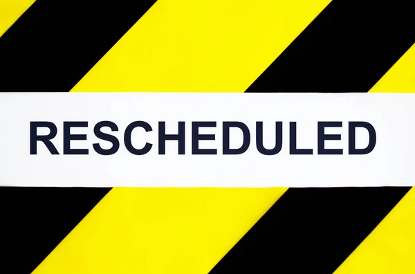 Rescheduled Text Tape Black Yellow Background — Stock Photo, Image