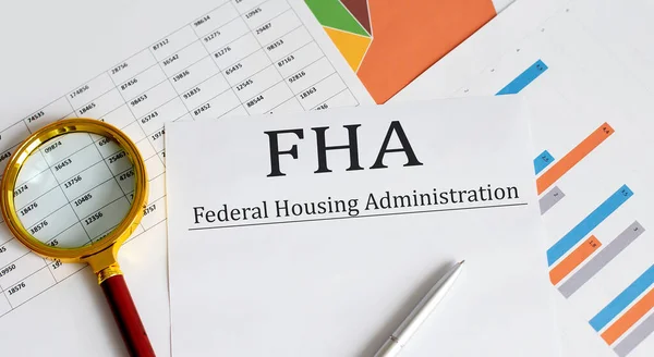 Paper with FHA loan on table with cart , pen and magnifier