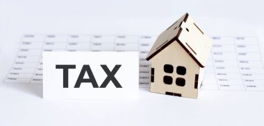 Dosya arkaplanındaki TAX yazıları için boş olan ev ahşap modelinin kapanışı.