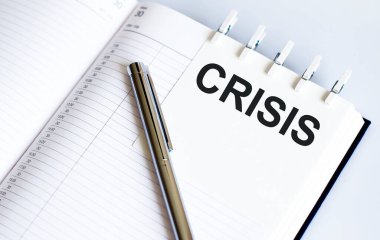 Kısa not dokusu arkaplanı üzerinde kalemle CRISIS metni