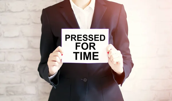 woman showing white card with PRESSED FOR TIME word in a close up shot. Business