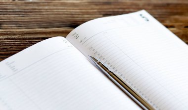 Ahşap masa üzerinde kalem ve kalem ile boş defter, iş konsepti