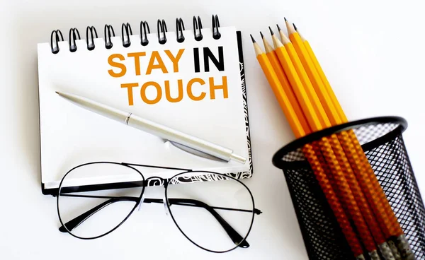 İş objeleri ve gözlüklerle not defterinde iletişimde kalın