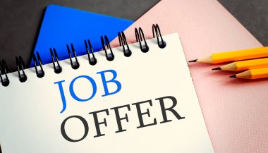 Ofis defterinde ofis aletleriyle birlikte iş teklifi mesajı. İş dünyası