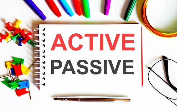 white text PASSIVE ACTIVE on the notepad , multi-colored felt-tip pens. Business