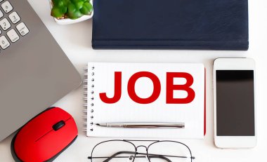 Ofis araçları ile beyaz arka planda metin işi içeren dizüstü bilgisayar, kalem ve not defteri