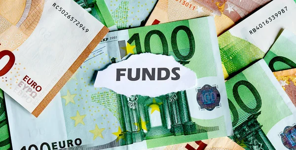 Focus on the word FUNDS , on piece of torn white paper with EUROS currency as a background. — Stock Photo, Image