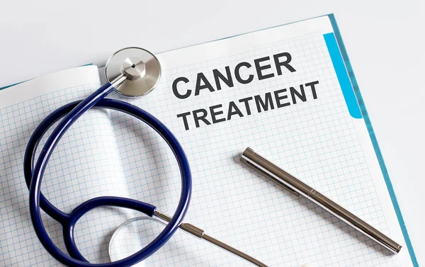 用听诊器在桌子上进行文字癌症治疗的纸 — 图库照片