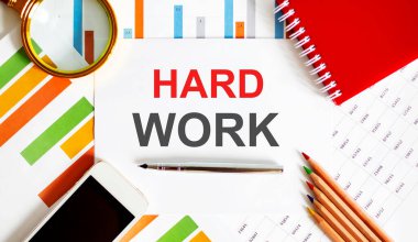Ofis araçları ile not defteri üzerinde HARD Work metni, mali rapor üzerinde kalem