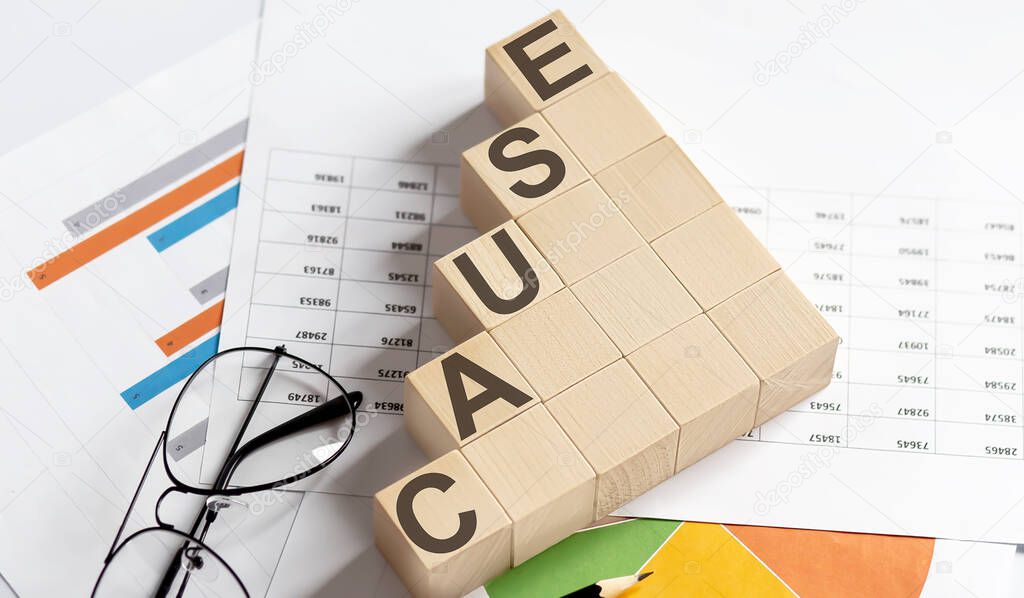 CAUSE words with wooden blocks on chart background. Business concept.
