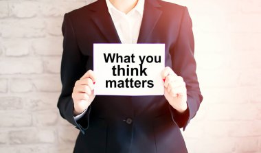 woman showing white card with WHAT YOU THINK MATTERS word . Business concept clipart