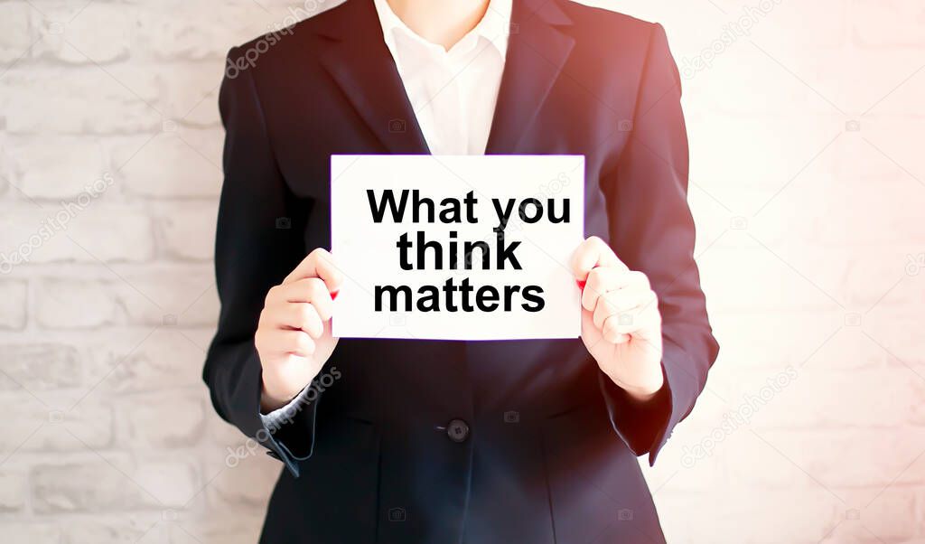 woman showing white card with WHAT YOU THINK MATTERS word . Business concept