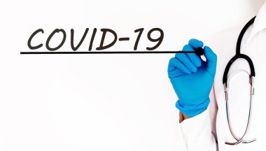 COVID-19 metni yazan doktor. Beyaz arkaplan üzerine tıbbi konsept.