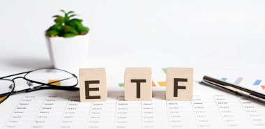 ETF kelime kavramı tahta bloklara yazılır, küpler çiçek, kalem ve bardaklar arkaplanda