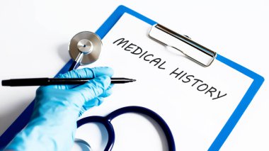 Steteskoplu bir masada EDICAL History yazılı kağıt. Tıbbi konsept
