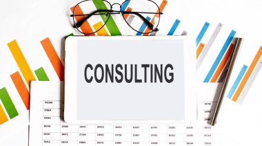 İş çizelgeleri ve kalem üzerine metin CONSULTING tableti