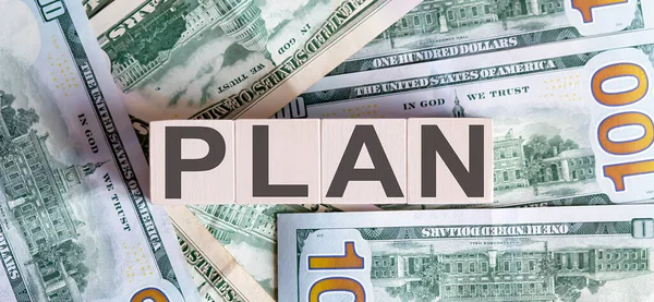 Dolar banknotlarından güzel bir arka planda tahta bloklar üzerinde plan yapmak..