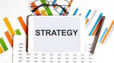 İş grafikleri, gözlükler, kalemler üzerine STRATEGY metin tableti