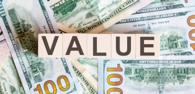 Tahta bloklardaki kavramsal sözcükler dolar banknotlarından güzel bir arka planda. İş dünyası