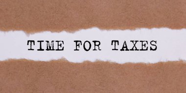 Beyaz arkaplanda yırtık kağıtların altına yazılan vergilerin zamanı