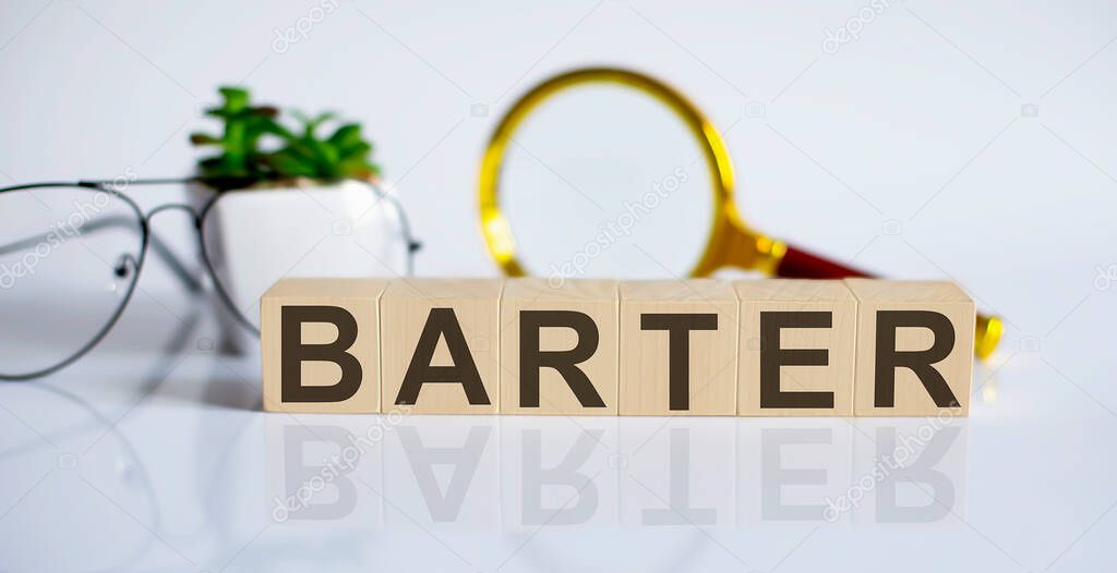 wooden word block BARTER on the white background with glasses and magnifier