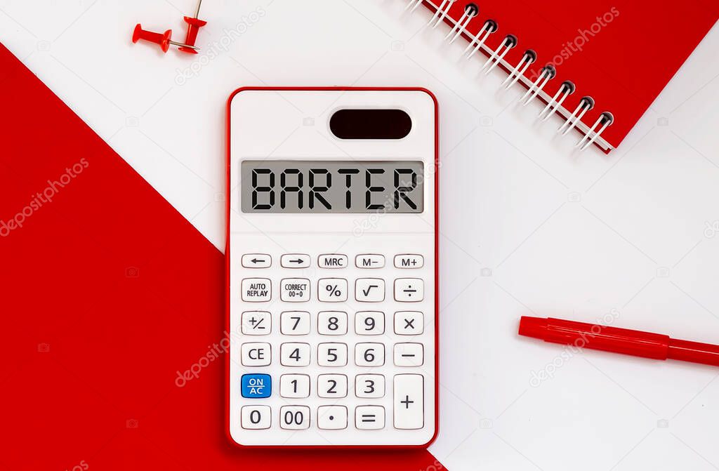 calculator with the word BARTER on display with red notepad and office tools