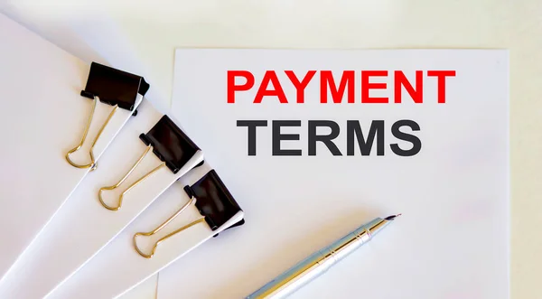 PAYMENT TERMS written on white page with office tools