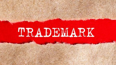 TRADEMARK yırtık kağıtların arkasında görünüyor.