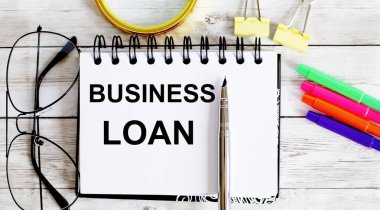 İş kredisi metni. Üst görünüm ofis masası, pazarlama planı için iş grafik programı. Kitap, kalem, sade kahve, ataç, büyüteç, dolar.