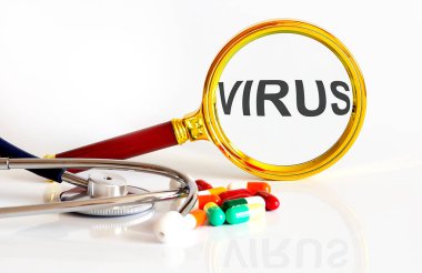 Tıbbi araçlar ve haplarla VIRUS mesajı ile büyüteç