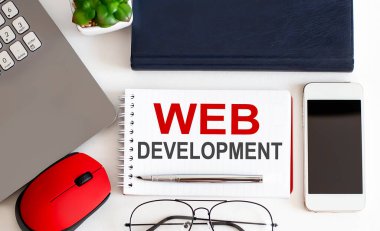 Dolma kalemli, dekoratif bitkili, klavyeli ve tahta zemin üzerinde not defteri olan bir web sitesi. İş konsepti