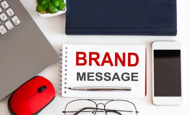 Not defteri, kalem, beyaz arka planda ofis araçları üzerine Brand MESSAGE metni. İş dünyası