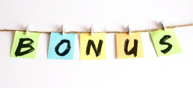 BONUS kavramı - beyaz arkaplanda kelime seosu olan renkli yapışkan notlar