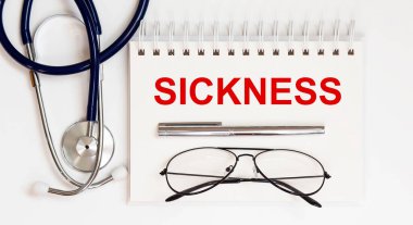 Stetoskop, gözlük ve kalemle beyaz arkaplanda bir SICKNESS