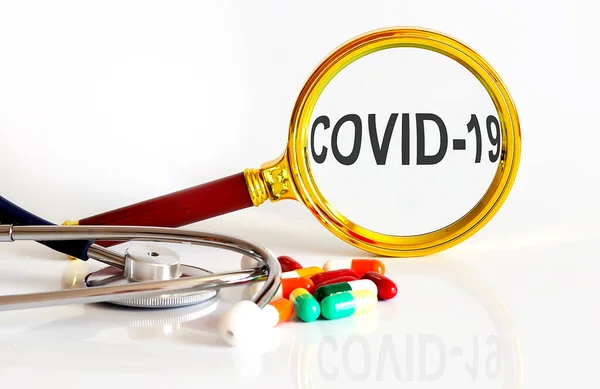 Vergrootlens Met Tekst Covid Met Medische Hulpmiddelen Pillen — Stockfoto